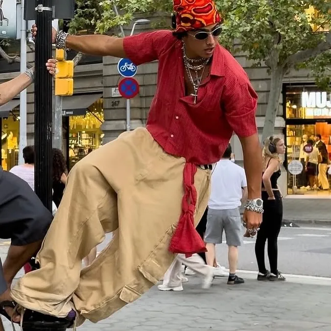 Skater mid-trick balanced on a bollard, red shirt and Two Frogs bandana